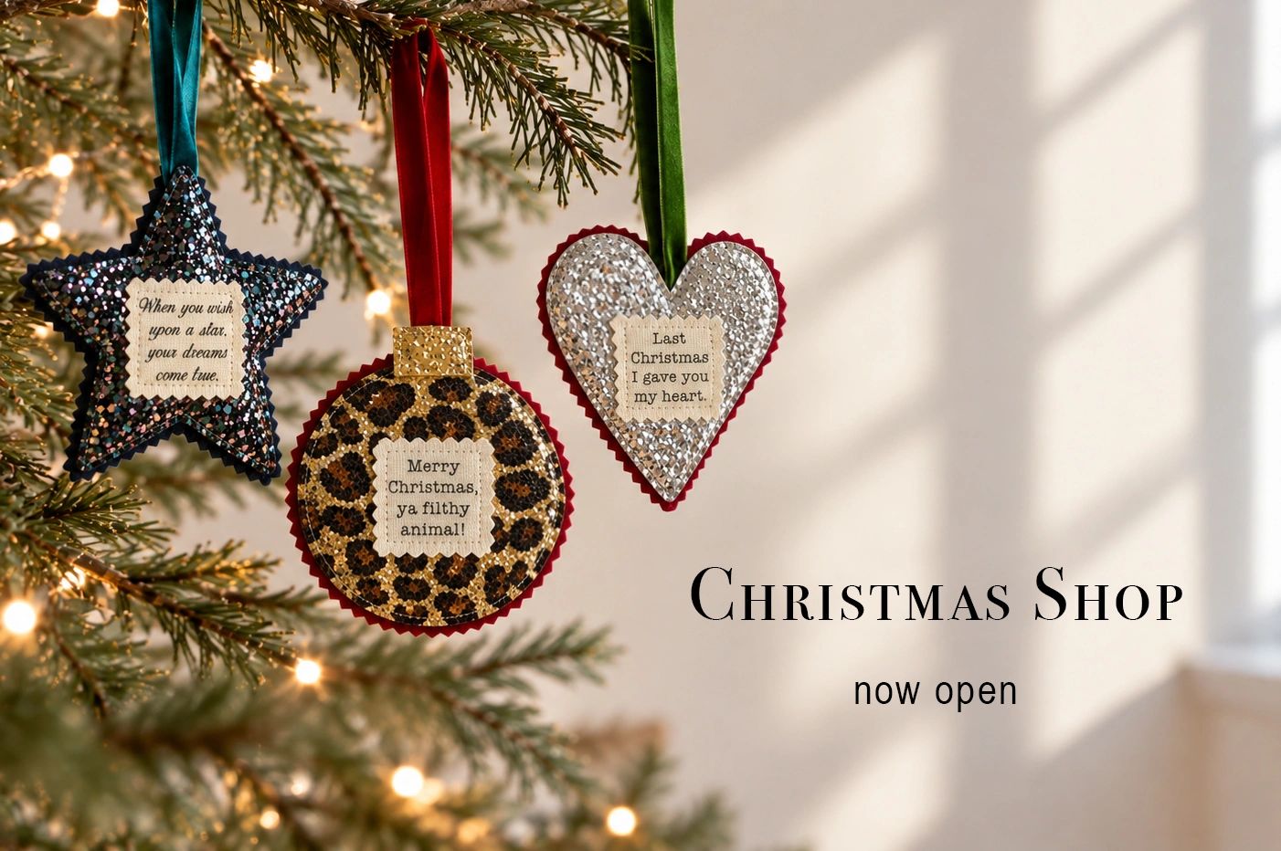display of handmade glitter christmas tree decprations and christmas shop now open text.