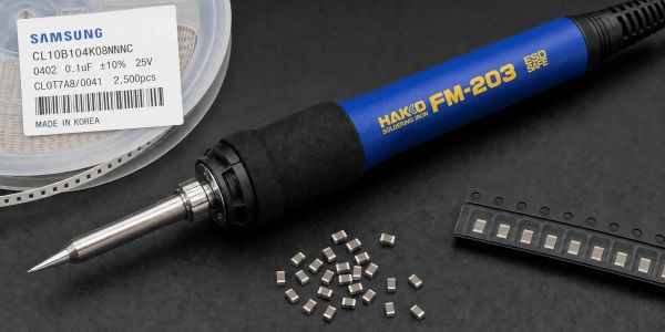 A Hakko FM-203 soldering iron with electronic components and Samsung capacitors.