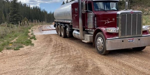 Large truck applying road treatment product on a dirt road