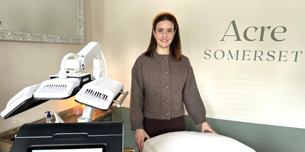 Woman standing next to spa treatment equipment and bed at Acre Somerset.