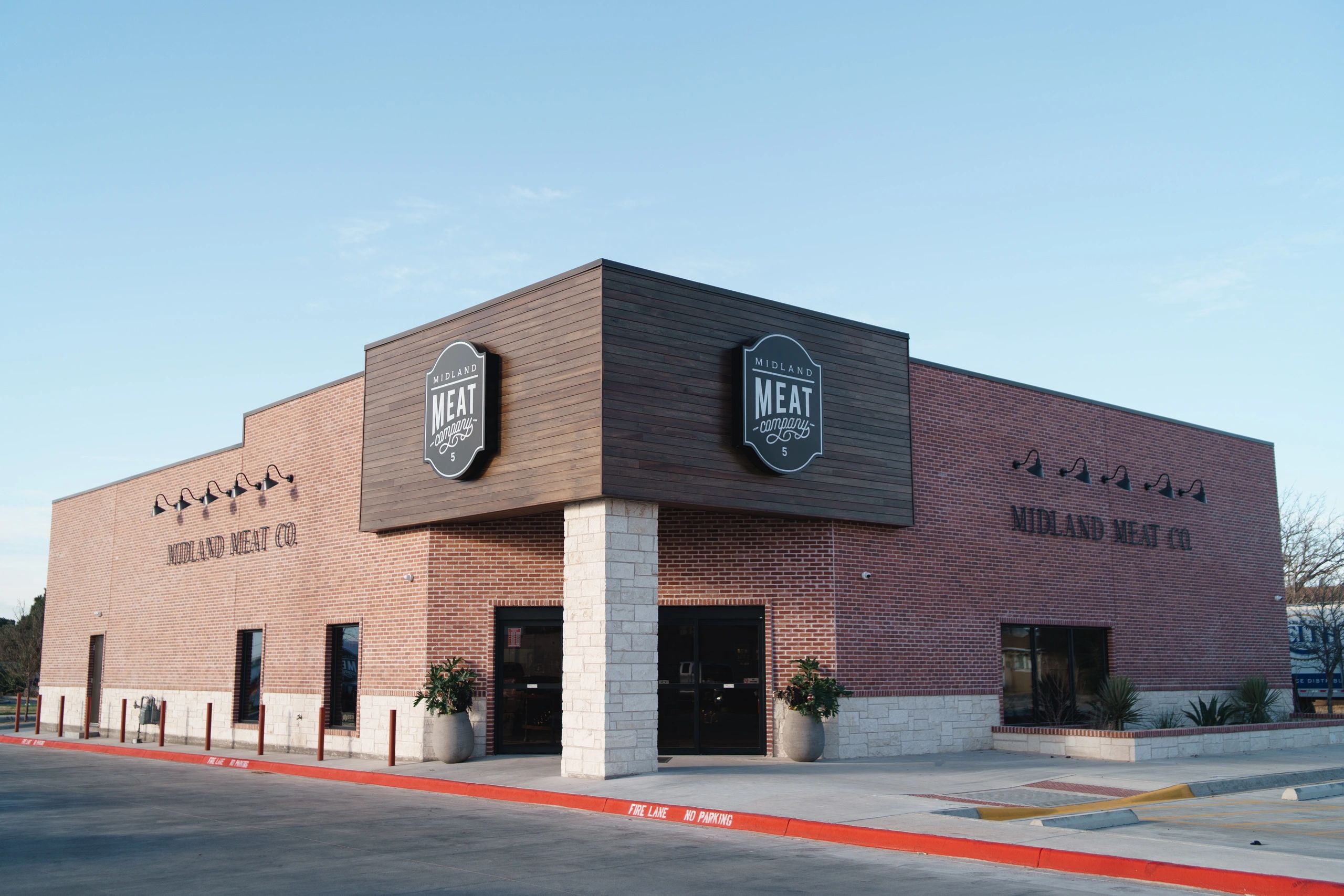 Modern brick building housing Midland Meat Co. with clear signage and well-maintained surroundings.