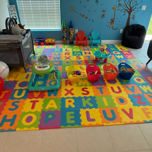 Colorful toddler playroom with alphabet foam mat and toys organized in baskets.
