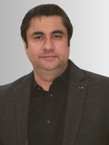 Man in dark blazer and black shirt.