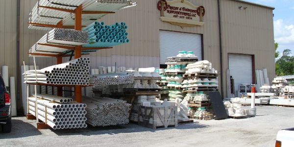 PVC pipes and construction materials outside a warehouse.