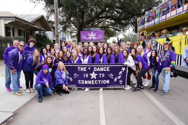 Large group celebrating The Dance Connection's 43rd anniversary in purple attire.