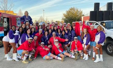 A large group of people in colorful athletic outfits posing outdoors with smiles.