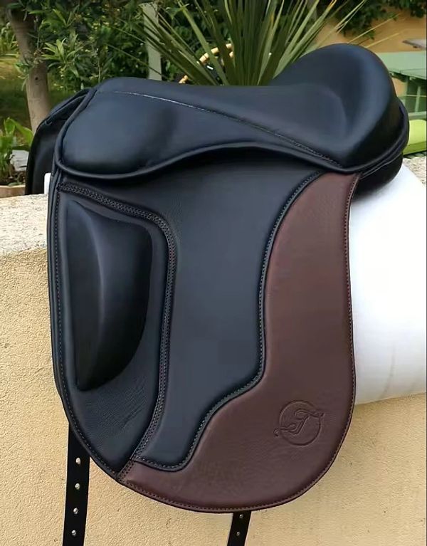Close-up of a black and brown horse saddle with detailed stitching.