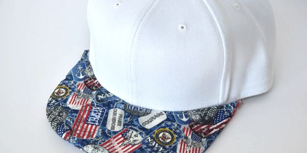 A white hat with Navy pattern brim covering.