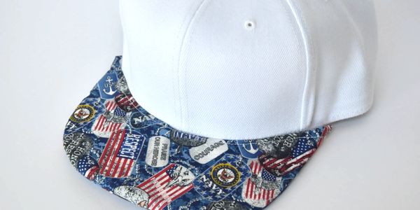 A white hat with Navy pattern brim covering.