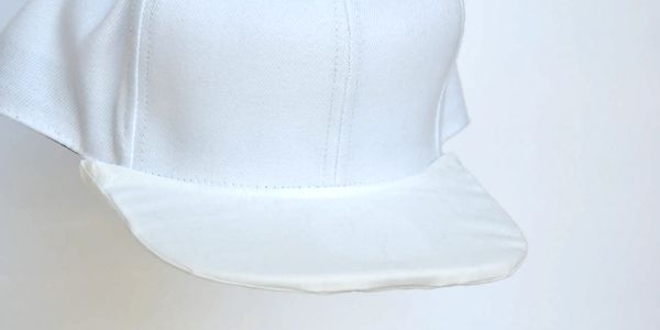 A white hat with a blank style brim covering.