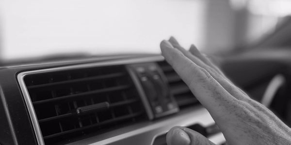 Hand adjusting car air vent.
