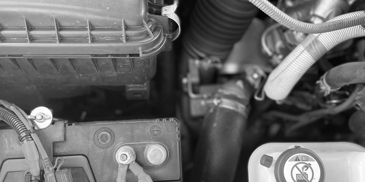 Close-up of a car engine's battery and components.