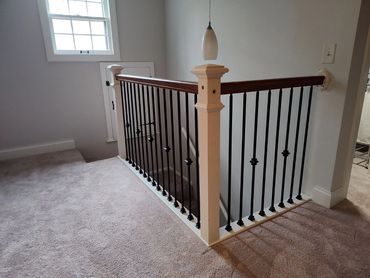 Removed existing white painted 2" x 2" railing with custom oak handrail and metal balusters.