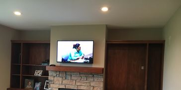 Built-in bookshelves installed on top of existing cabinets flanking fireplace in family room. 
