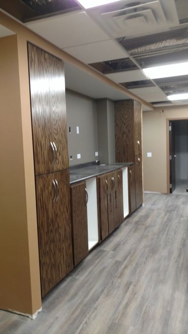 Oak front office cabinets and shelves. ADA accessible desk. Laminate countertop. Locking cash drawer