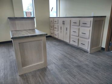 Oak front office cabinets and shelves. ADA accessible desk. Laminate countertop. Locking cash drawer
