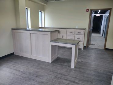 Oak front office cabinets and shelves. ADA accessible desk. Laminate countertop. Locking cash drawer