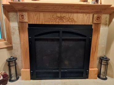 Custom Oak gas fireplace surround trim with mantel and decorative pieces. 