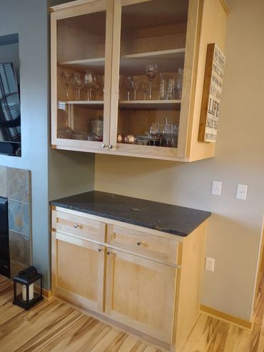 Maple upper and lower cabinets with granite countertop. Matches existing style. Soft close hardware
