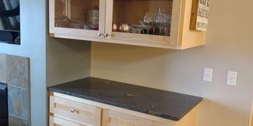 Maple upper and lower cabinets with granite countertop.  Glass doors and soft close drawer and door 