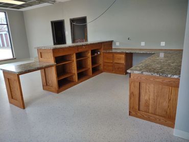 Oak front office cabinets and shelves. ADA accessible desk. Laminate countertop. Locking cash drawer