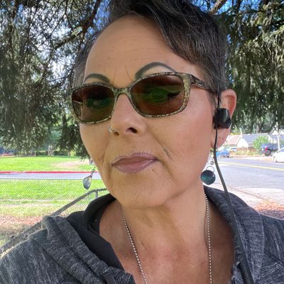 Woman wearing eyeglasses with headphones In ear with looking ahead