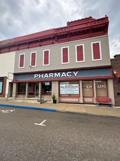 Old-fashioned pharmacy storefront on a cloudy day.