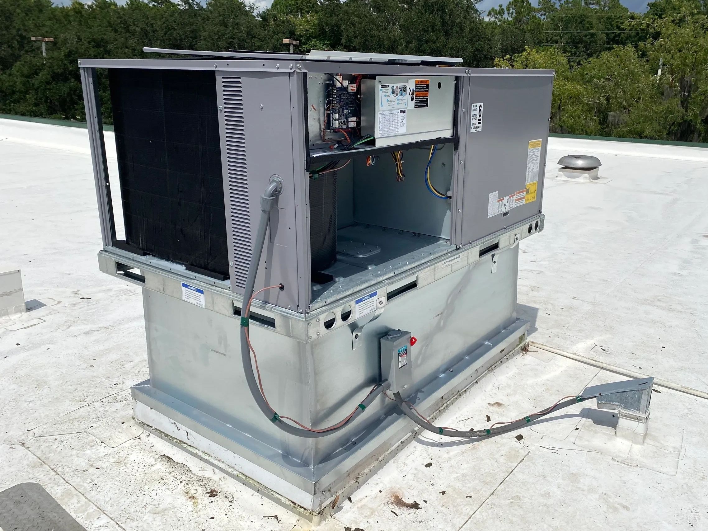 Open rooftop HVAC unit with visible internal components and wiring.
