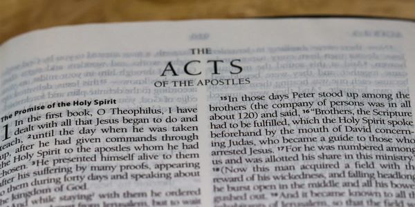 Open Bible showing the beginning of Acts of the Apostles.