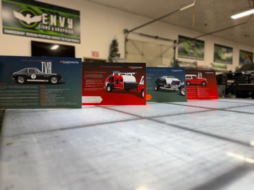 Informational cards about classic cars on a table.