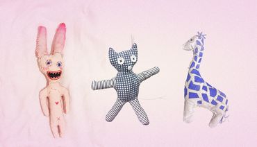 Three handmade stuffed toys on a pink background.