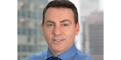 Professional man in blue shirt and tie with cityscape background.