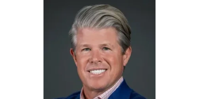 Portrait of a smiling middle-aged man with gray hair in a blue suit.