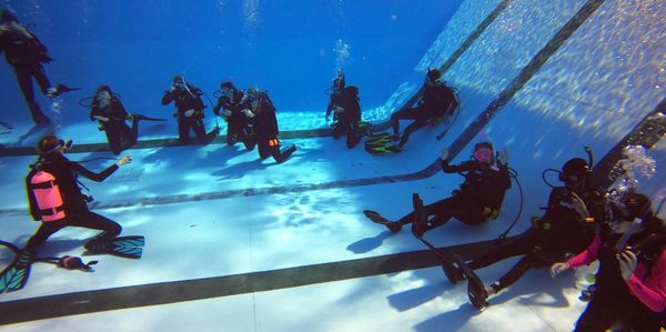 Scuba divers practicing skills in the pool during their certification class in Miami Florida