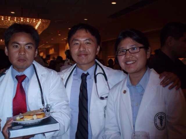 Three medical professionals in white coats at an indoor event.