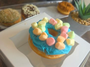 Colorful marshmallow donut with blue frosting.