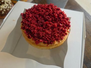 A round cake topped with red crumbles.