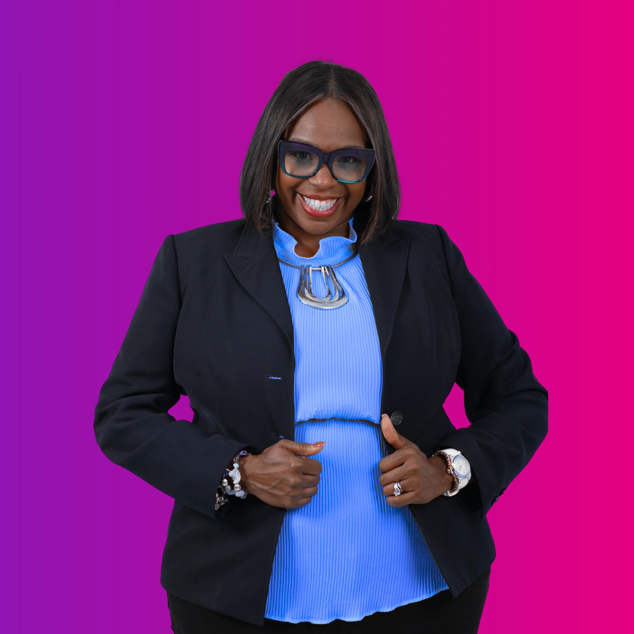 Confident woman in glasses, black blazer, and blue top against vibrant purple-pink background.