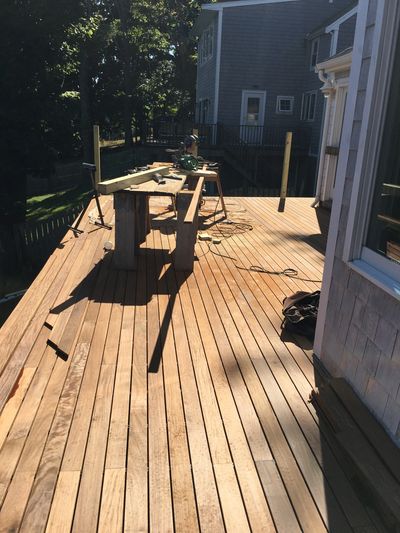Wooden deck under construction with tools and lumber scattered around.