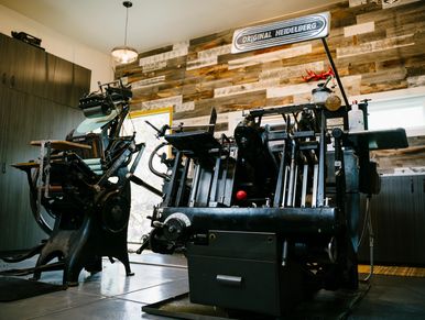 Vintage Heidelberg printing press in a rustic workshop.