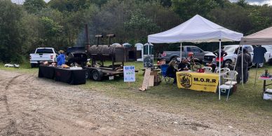 Outdoor event with tents and smokers.