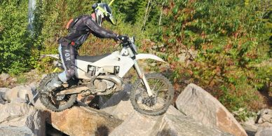 Motorcyclist jumps over rocks on dirt bike.