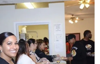 People serving food at a church homeless shelter.