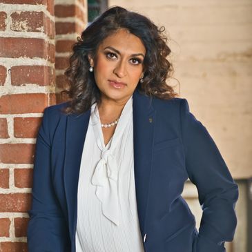 image of woman standing next to brick wall
