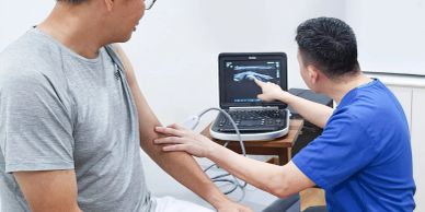 Doctor performing an ultrasound on a patient's arm.