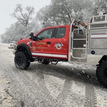 Red Calvert Fire Department truck on snowy road during winter.