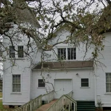 Old white wooden house with ramp and bare tree branches. Independent Missionary Baptist Church. Earl