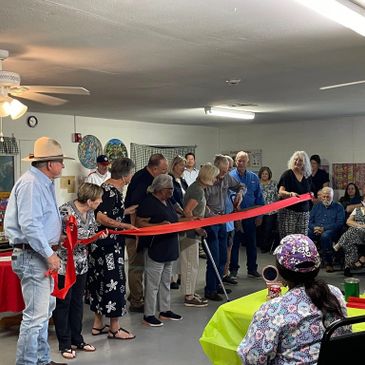 Community members gather indoors for a ribbon-cutting ceremony.
