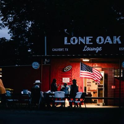 Evening at Lone Oak Lounge with people gathered outside.
