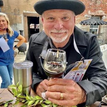 Man enjoying a drink at a Moonfest event, smiling warmly.